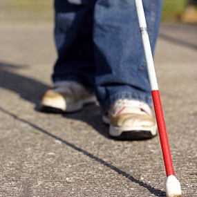 White and red cane and person's feet