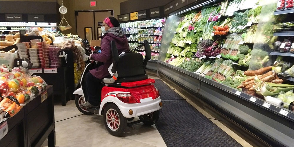 disabled woman shopping for groceries on scooter