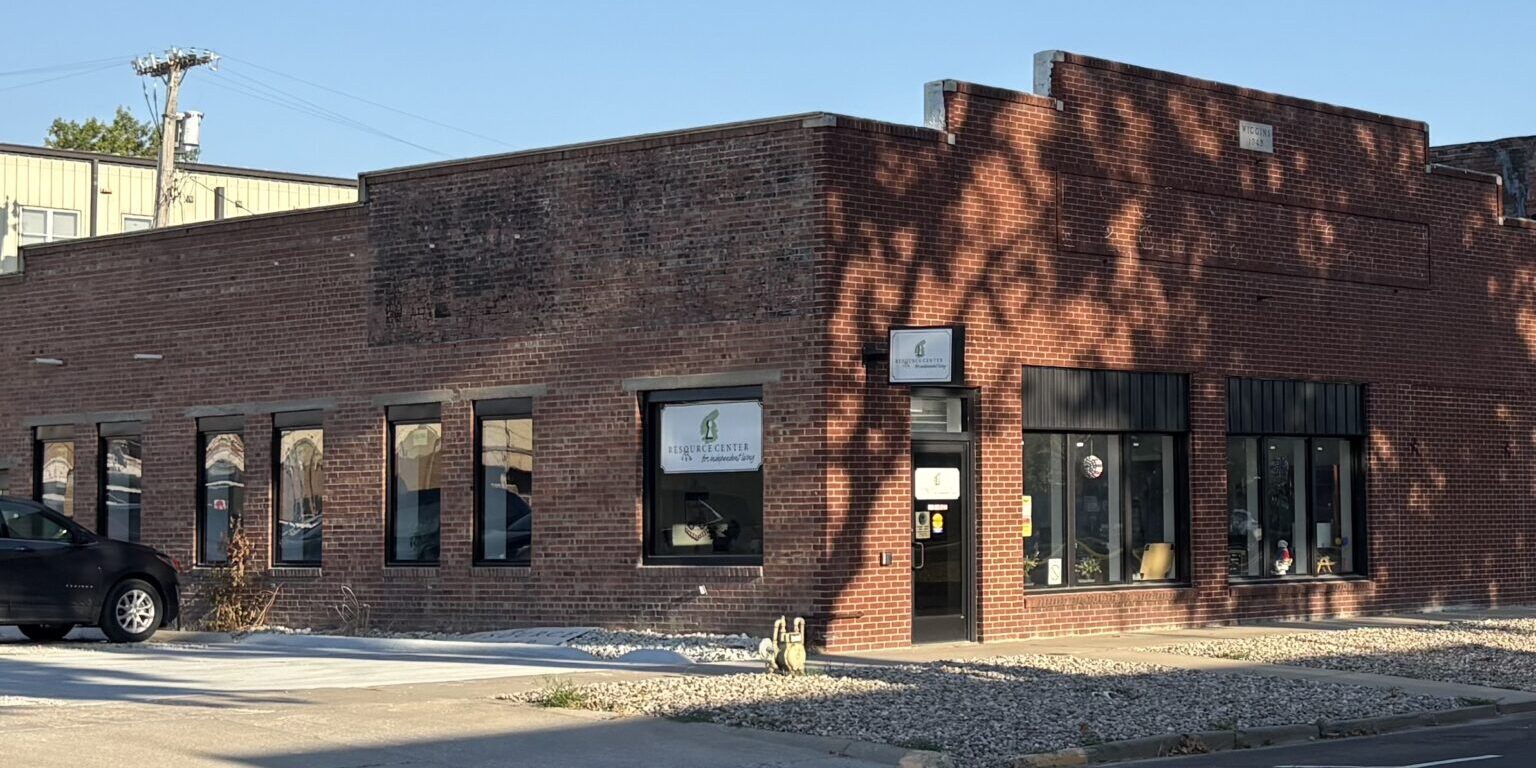 The corner of a red brick single story building with windows on both sides